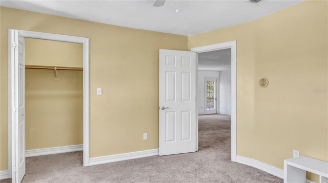 unfurnished bedroom with light carpet, a closet, and ceiling fan