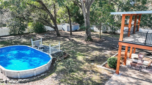 view of pool with a shed, a wooden deck, and a patio