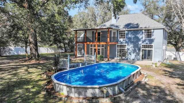 view of pool with french doors, a patio area, and a lawn