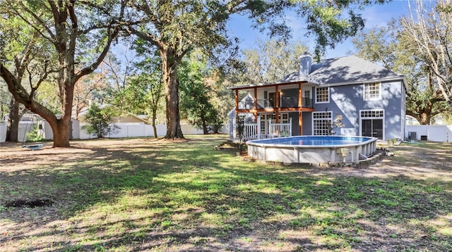 view of yard with cooling unit, a balcony, and a fenced in pool