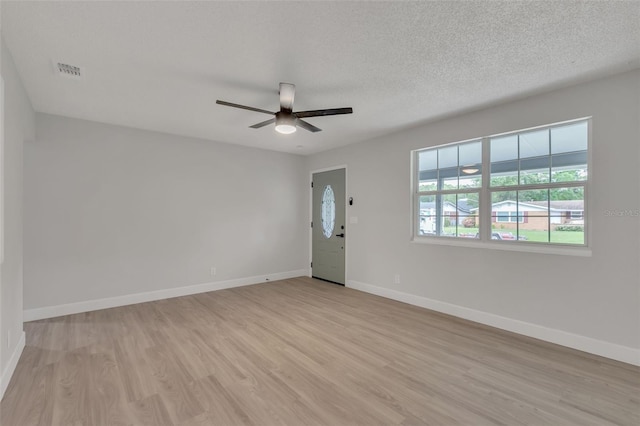 unfurnished room featuring ceiling fan, a textured ceiling, and light hardwood / wood-style floors