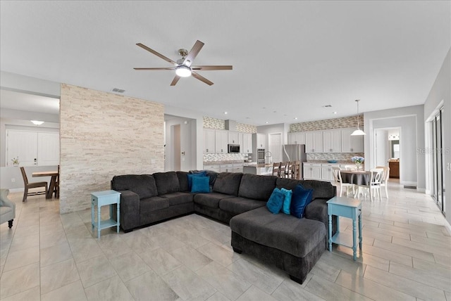 tiled living room featuring ceiling fan