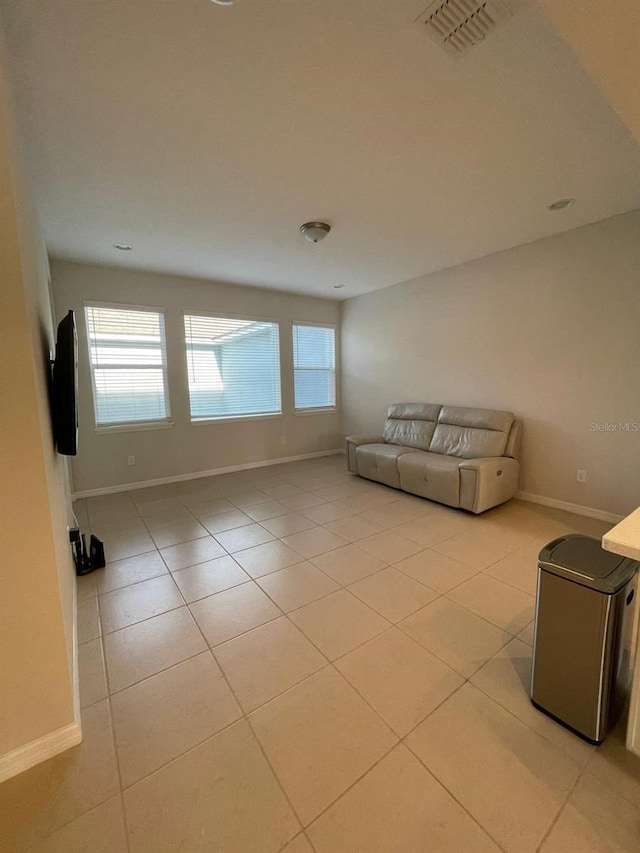 unfurnished living room with light tile patterned floors and a healthy amount of sunlight