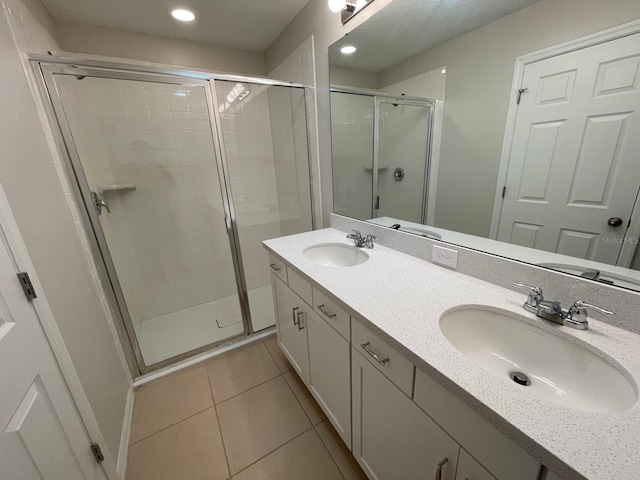 bathroom with tile patterned flooring, vanity, and walk in shower