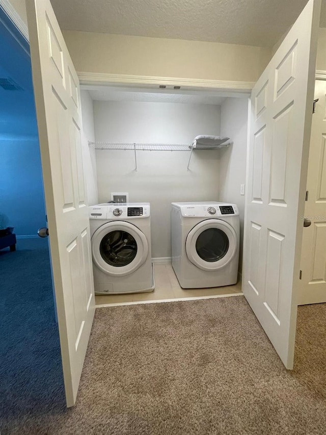 washroom featuring washer and dryer, a textured ceiling, and carpet