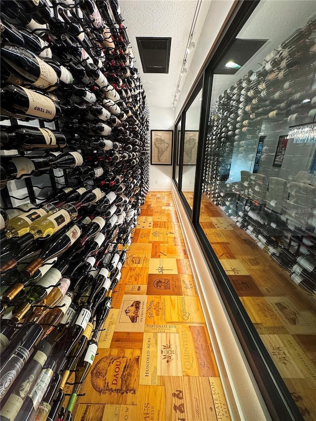 wine area featuring light hardwood / wood-style floors and a textured ceiling