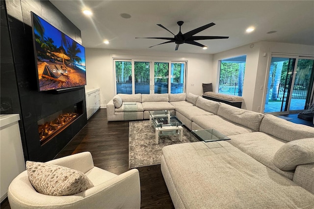 living room with ceiling fan and dark hardwood / wood-style flooring