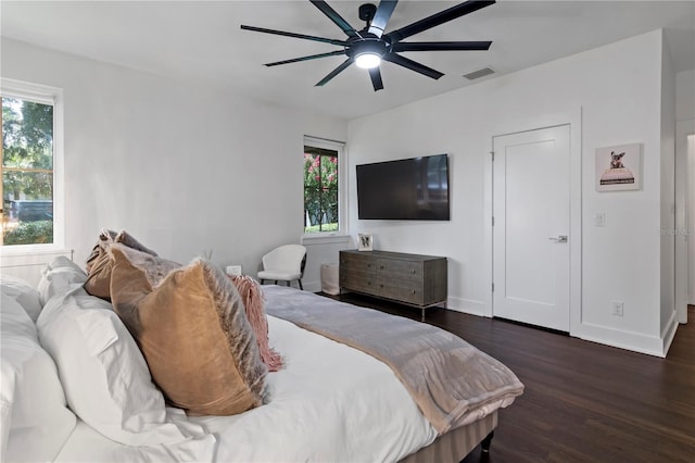 bedroom with dark hardwood / wood-style flooring and ceiling fan