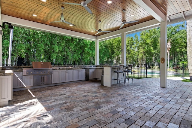 view of patio / terrace featuring exterior kitchen, grilling area, and ceiling fan