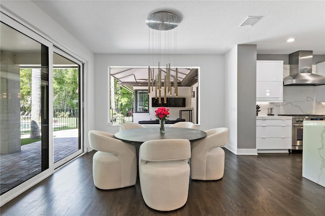 dining room featuring dark hardwood / wood-style flooring and a textured ceiling