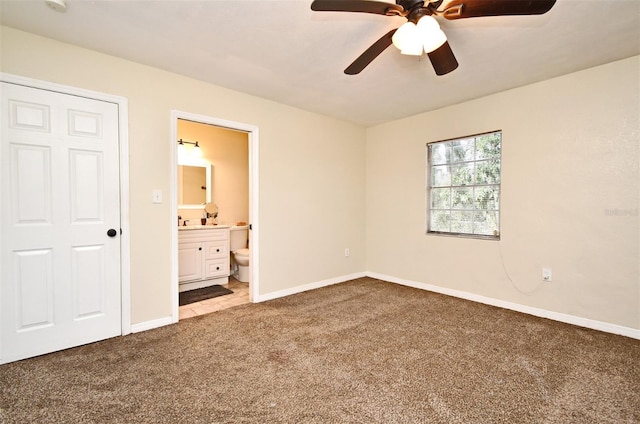 unfurnished bedroom featuring light carpet, ensuite bath, and ceiling fan