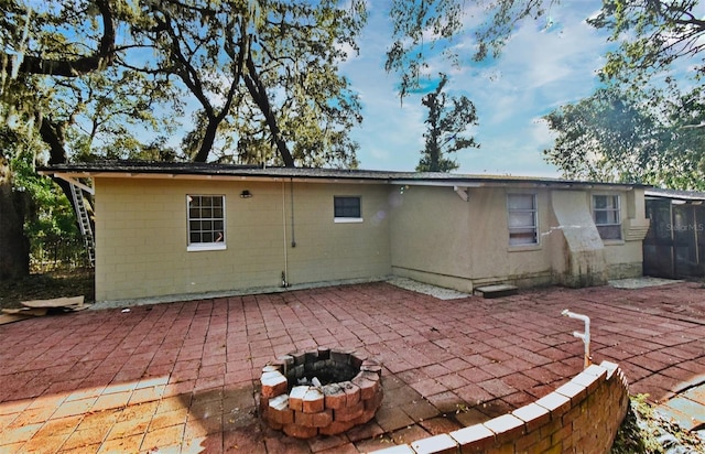 back of property featuring a patio area and a fire pit