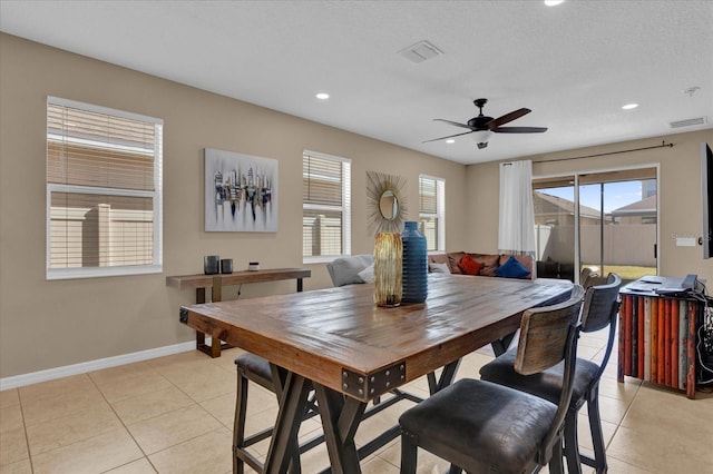 dining area with ceiling fan, a textured ceiling, and light tile patterned flooring