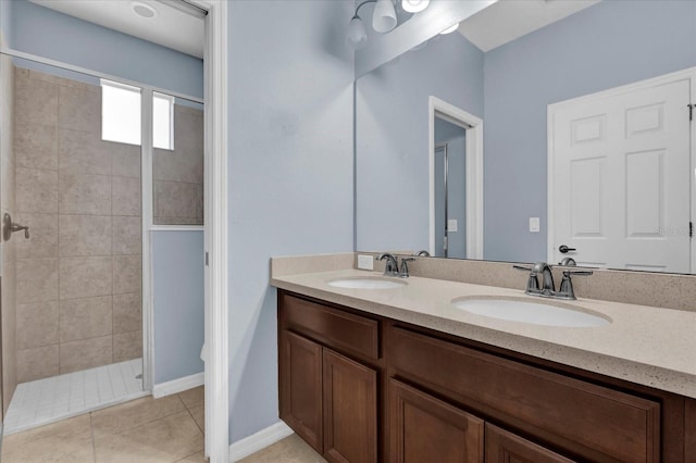 bathroom featuring vanity, tile patterned flooring, and a tile shower