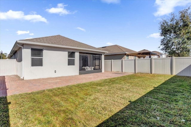 rear view of property with a patio, a sunroom, and a yard