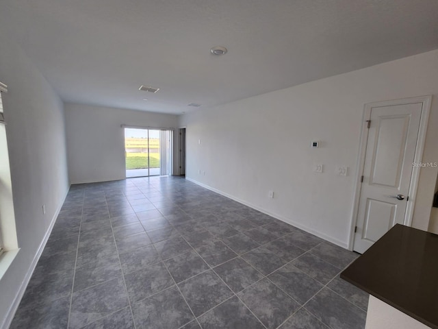 spare room featuring dark tile patterned flooring