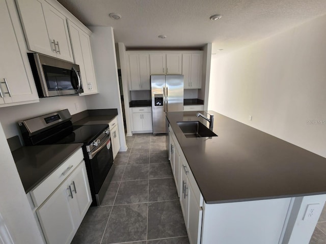 kitchen featuring white cabinetry, stainless steel appliances, sink, and a textured ceiling