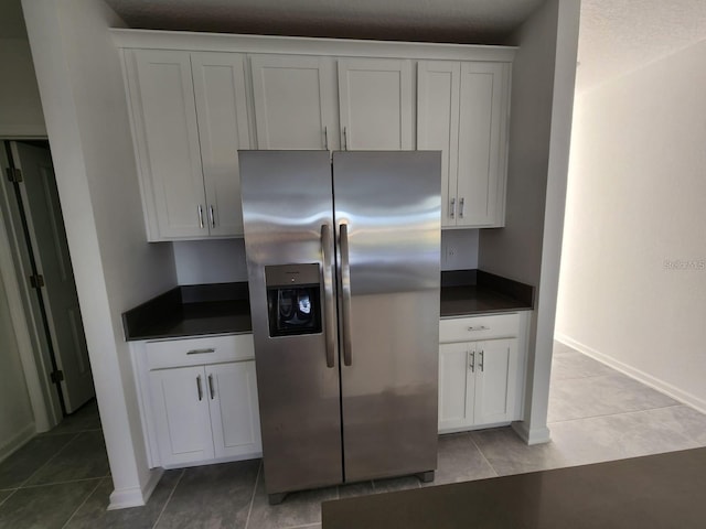 kitchen with white cabinetry, stainless steel fridge with ice dispenser, and light tile patterned floors