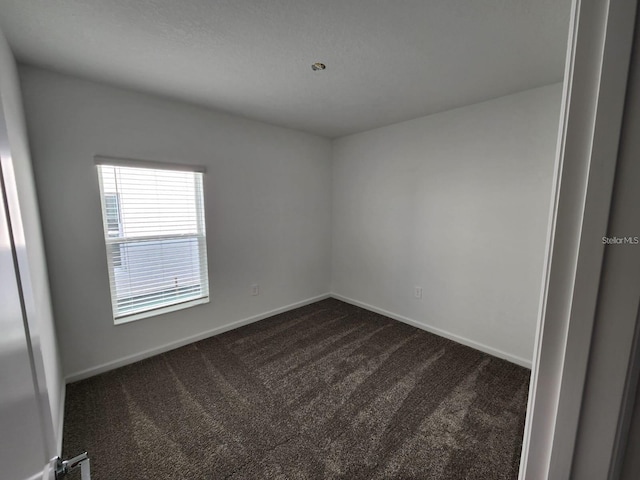 empty room with dark colored carpet