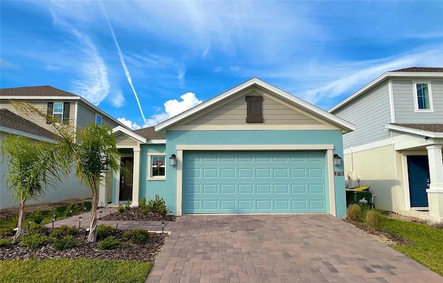 ranch-style house featuring an attached garage, decorative driveway, and stucco siding