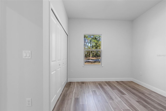 unfurnished bedroom with light hardwood / wood-style flooring and a closet