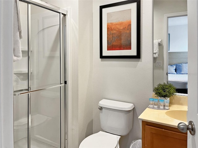 bathroom with toilet, an enclosed shower, and vanity