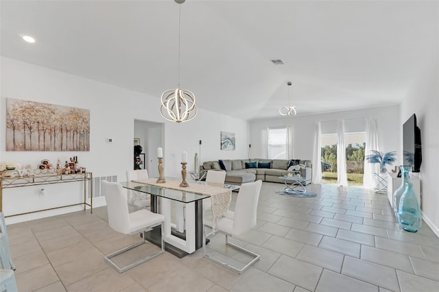 tiled dining space with an inviting chandelier