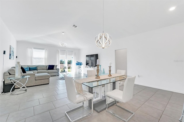 tiled dining room with lofted ceiling and a chandelier