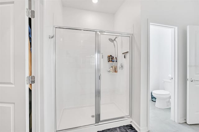 bathroom with a shower with shower door and toilet