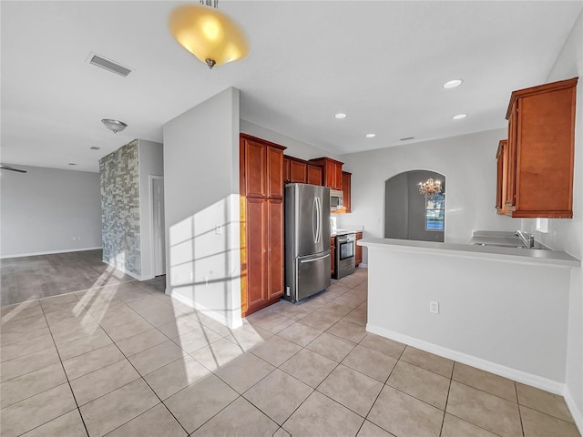 kitchen featuring appliances with stainless steel finishes, kitchen peninsula, sink, and light tile patterned floors