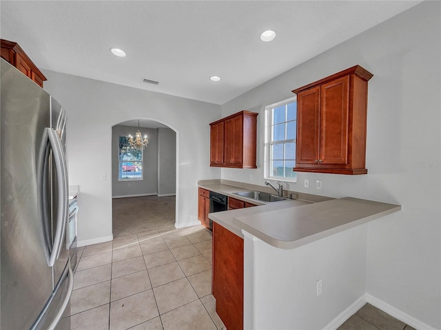 kitchen with stainless steel refrigerator, black dishwasher, sink, and light tile patterned floors