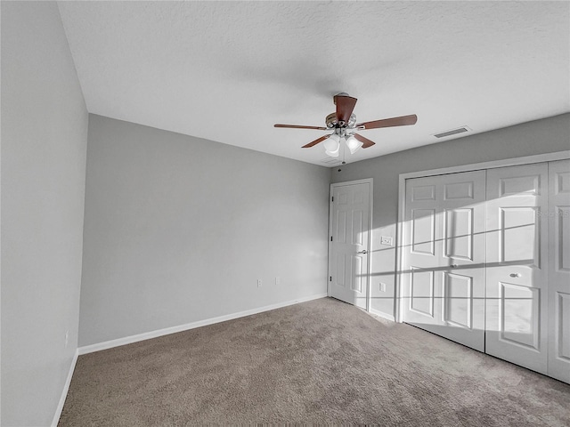 carpeted spare room with a textured ceiling and ceiling fan