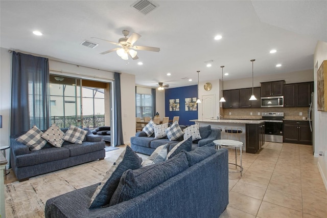 living room with sink, ceiling fan, and light tile patterned flooring