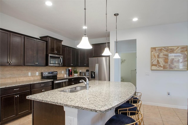 kitchen featuring sink, decorative light fixtures, dark brown cabinets, an island with sink, and stainless steel appliances