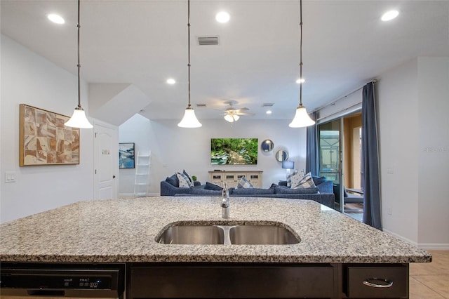 kitchen with an island with sink, dark brown cabinets, black dishwasher, and sink