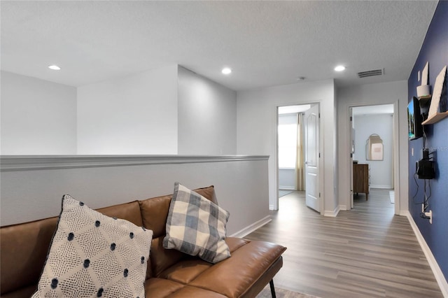 sitting room with wood-type flooring and a textured ceiling