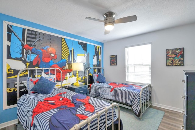 bedroom with hardwood / wood-style flooring, ceiling fan, and a textured ceiling