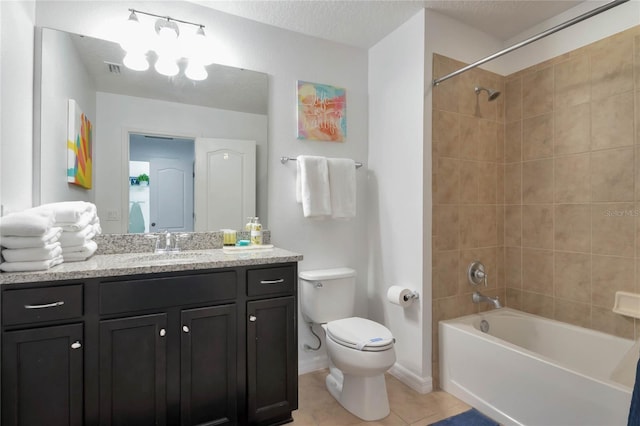 full bathroom with tile patterned floors, toilet, tiled shower / bath, a textured ceiling, and vanity