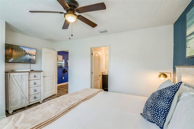 bedroom with ensuite bathroom, hardwood / wood-style floors, a textured ceiling, and ceiling fan