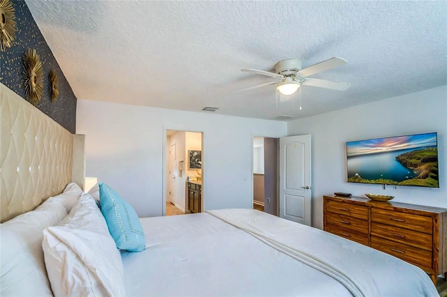 bedroom with connected bathroom, ceiling fan, and a textured ceiling