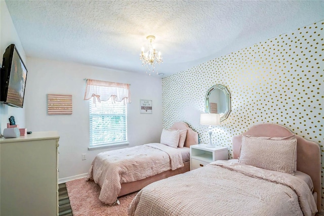 bedroom with hardwood / wood-style floors, a textured ceiling, and a chandelier