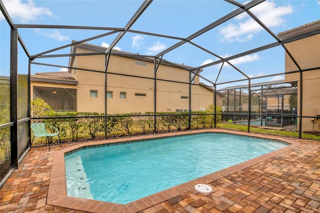 view of pool featuring a patio and glass enclosure