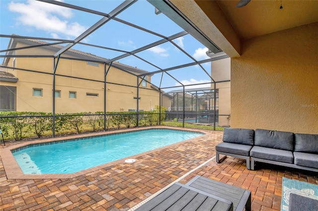 view of swimming pool with a patio, an outdoor hangout area, and glass enclosure