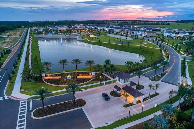 aerial view at dusk featuring a water view