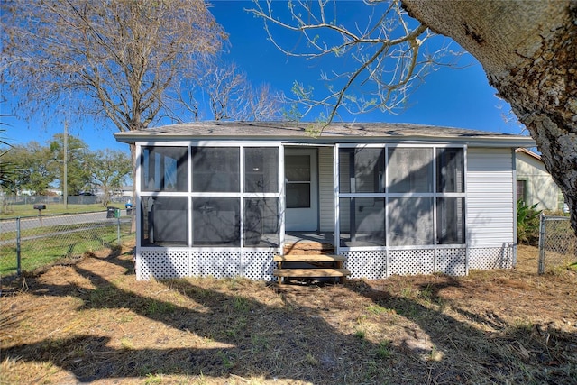 rear view of property with a sunroom and fence