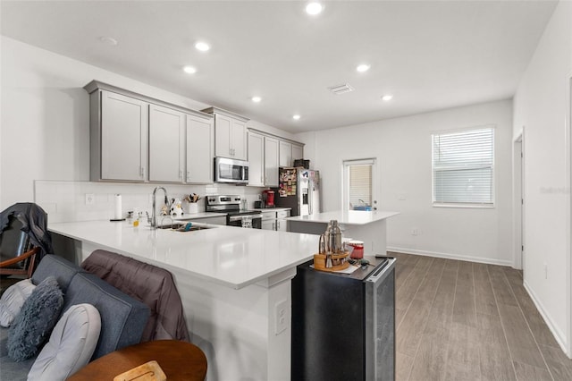 kitchen featuring appliances with stainless steel finishes, a breakfast bar, sink, and kitchen peninsula