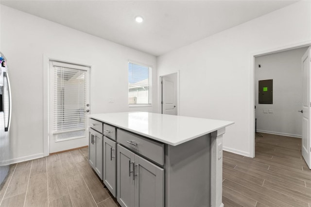 kitchen featuring gray cabinets, electric panel, and a center island