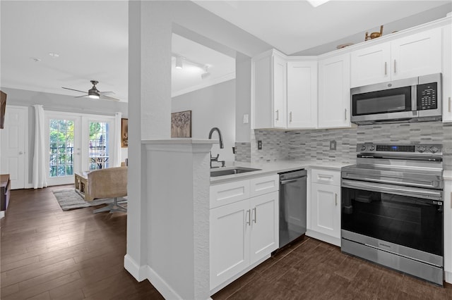 kitchen featuring stainless steel appliances, tasteful backsplash, sink, and white cabinets