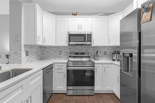 kitchen featuring stainless steel appliances, white cabinetry, dark wood-type flooring, and tasteful backsplash