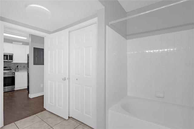 bathroom featuring bathing tub / shower combination, tile patterned floors, backsplash, and electric panel